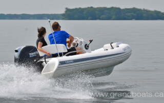 Boating in a GRAND golden line 11’10” long luxury fiberglass rigid inflatable boat (RIB) tender with steering console, seating, storage, bow step-plate.
