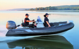 Boating in a GRAND Golden line 13’9″ long luxury rigid inflatable boat (RIB) tender in black; fiberglass hull, yamaha 70hp outboard motor, steering console with seat & storage, bow seat & storage, and bow step plate.