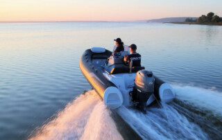 Boating in a GRAND Golden line 13’9″ long luxury rigid inflatable boat (RIB) tender in black; fiberglass hull, yamaha 70hp outboard motor, steering console, and bow step plate.