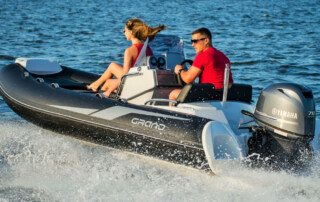 Boating in a GRAND Golden line 13’9″ long luxury rigid inflatable boat (RIB) tender in black; fiberglass hull, yamaha 70hp outboard motor, steering console, and bow step plate.