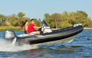 Boating in a GRAND Golden line 13’9″ long luxury rigid inflatable boat (RIB) tender in black; fiberglass hull, yamaha 70hp outboard motor, steering console, and bow step plate.