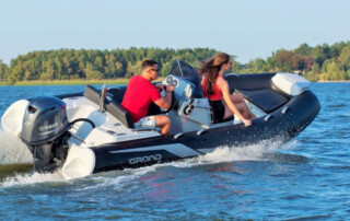 Boating in a GRAND Golden line 13’9″ long luxury rigid inflatable boat (RIB) tender in black; fiberglass hull, yamaha 70hp outboard motor, steering console, and bow step plate.