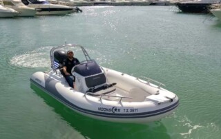 Boating front view in a GRAND golden line 16’3″ long luxury rigid inflatable boat (RIB) in black & white with a fiberglass hull.